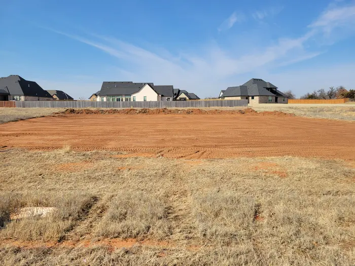 Clean leveled building pad with perimeter berm and machine tracks