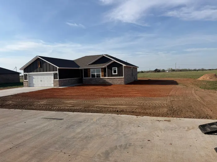 Final grade spread around a finished new build beside the fresh concrete driveway