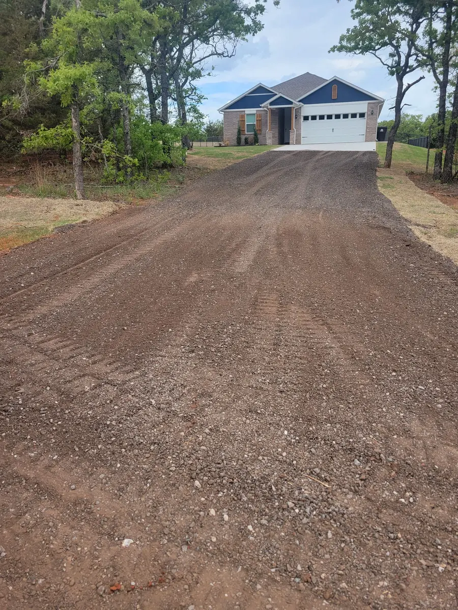 Fresh gravel driveway rising to a new home